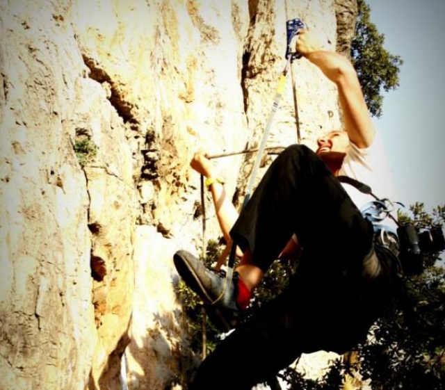  man with a smile climbing a natural rock 